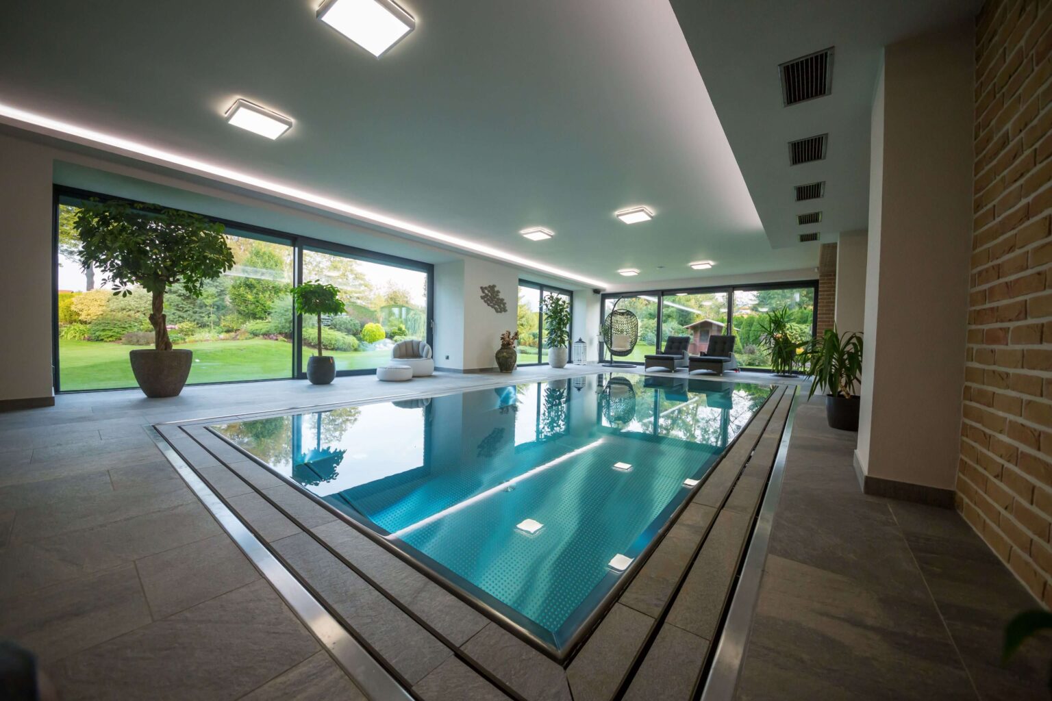 Rodinný nerezový bazén s přelivem zakrytým dlažbou