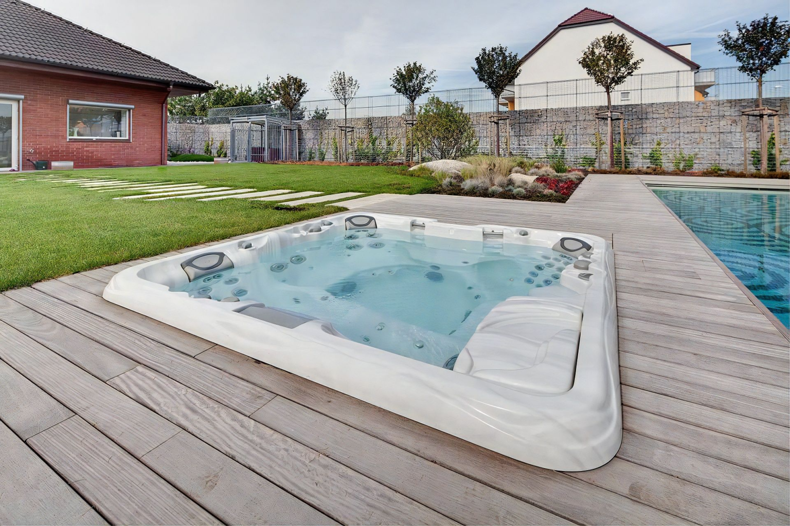 Rodinná vířivá vana Cameo zapuštěná vedle bazénu
